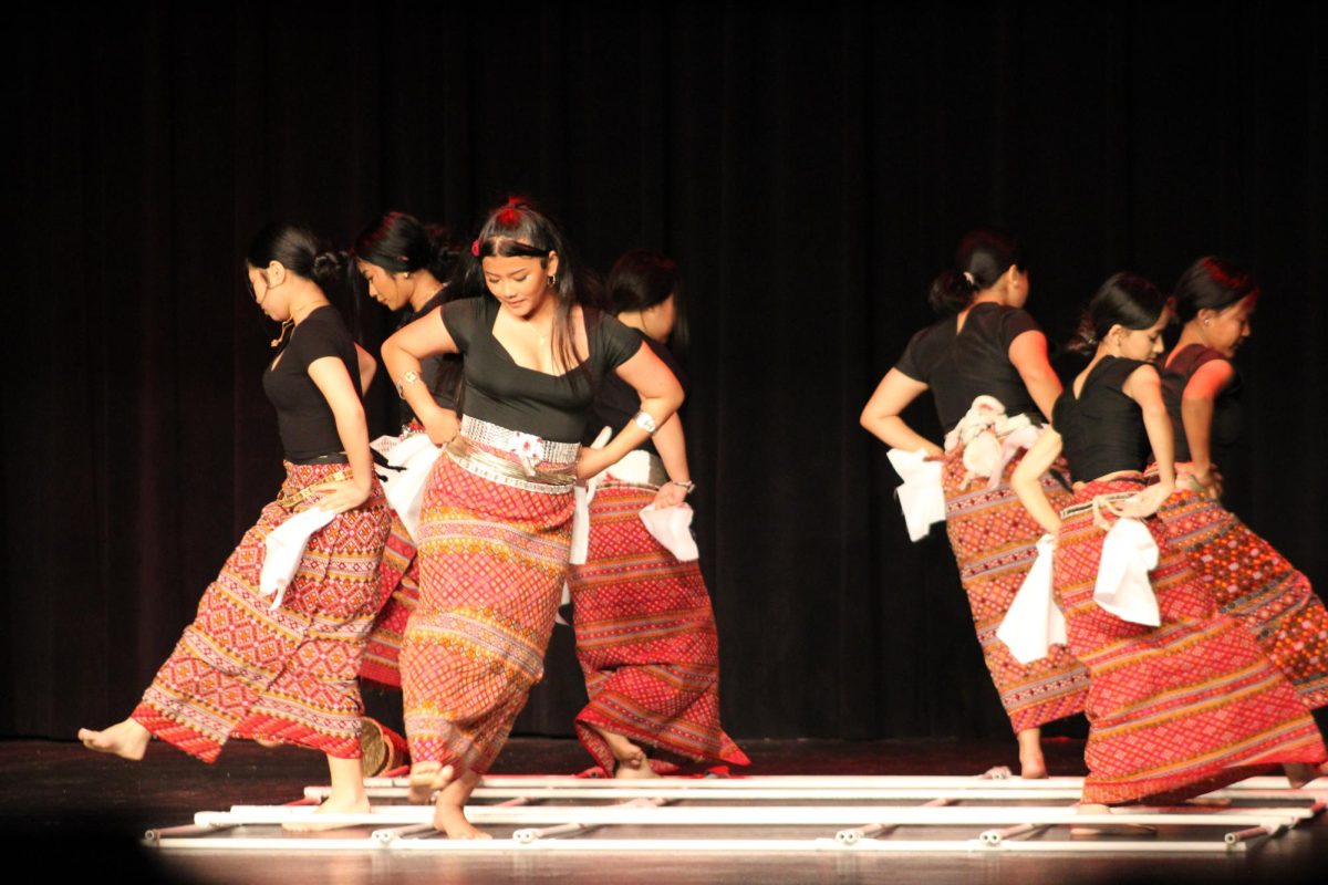 A group preforming a Burmese Bamboo Dance.